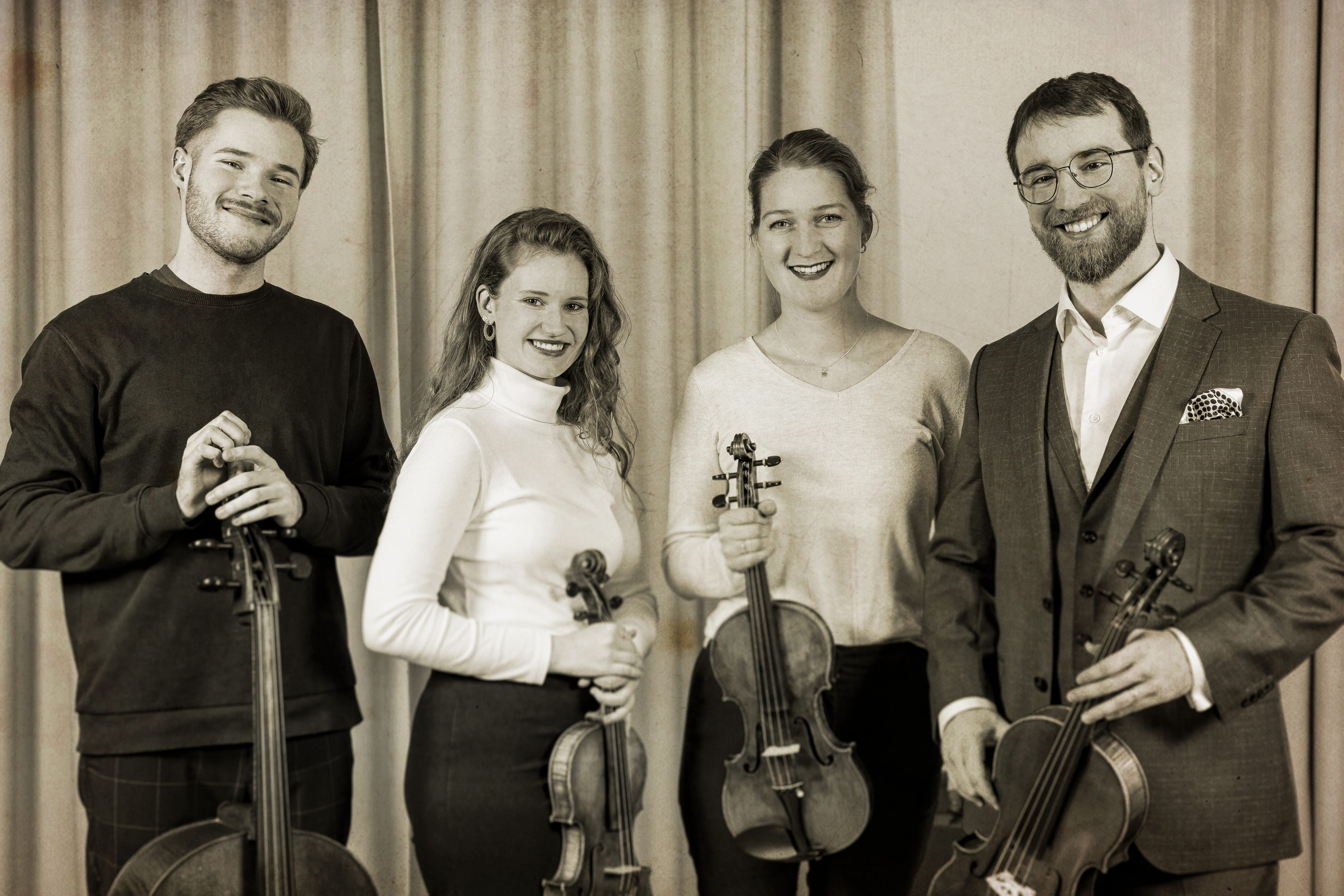 zwei Musikerinnen und zwei Musiker mit ihren Streichinstrumenten. Die Fotografie ist in Sepiafarben.