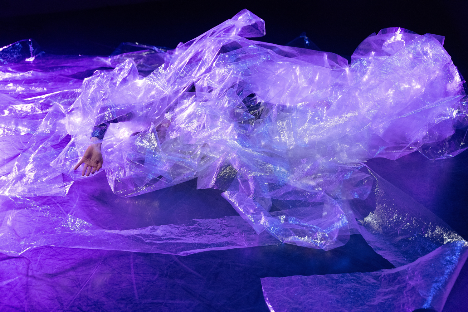 violett angeleuchtete Folie auf dem Boden, eine Person drin tanzend.