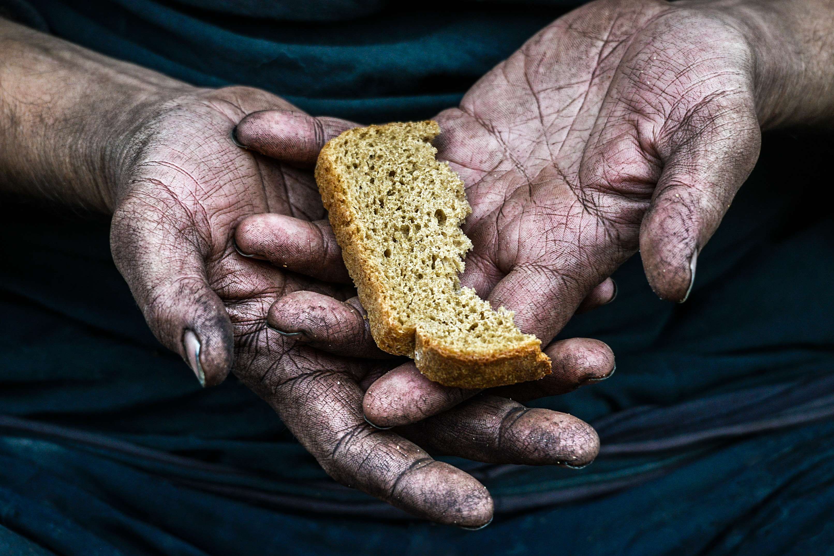Hände mit Brot auf der Innenseite der Handfläche