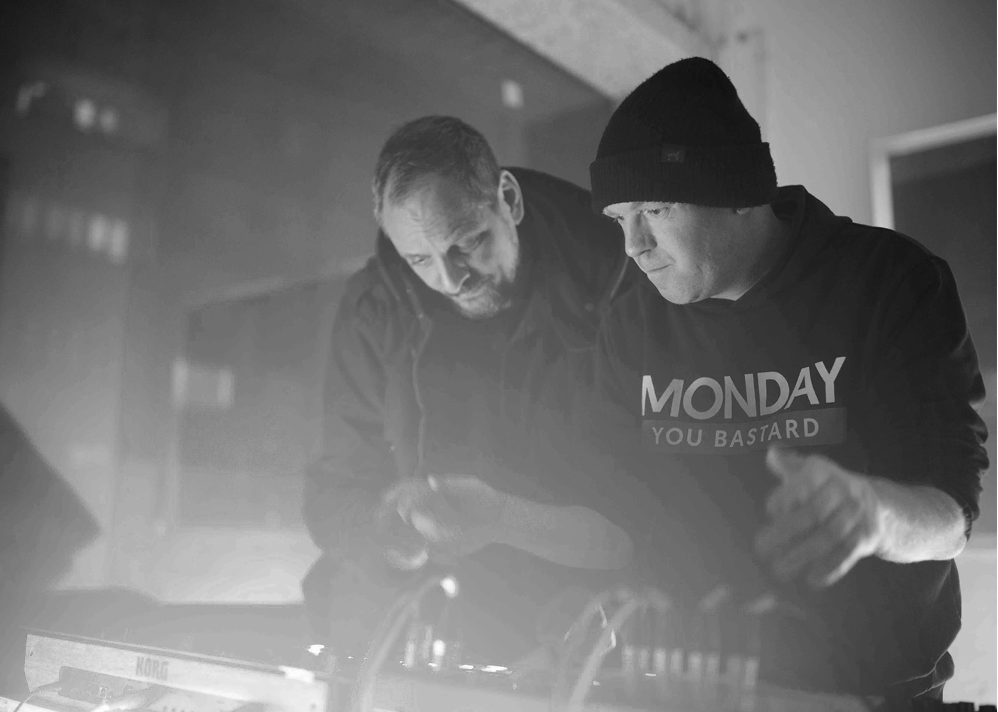 2 Personen stehen hinter einem Dj Pult und spielen Musik.