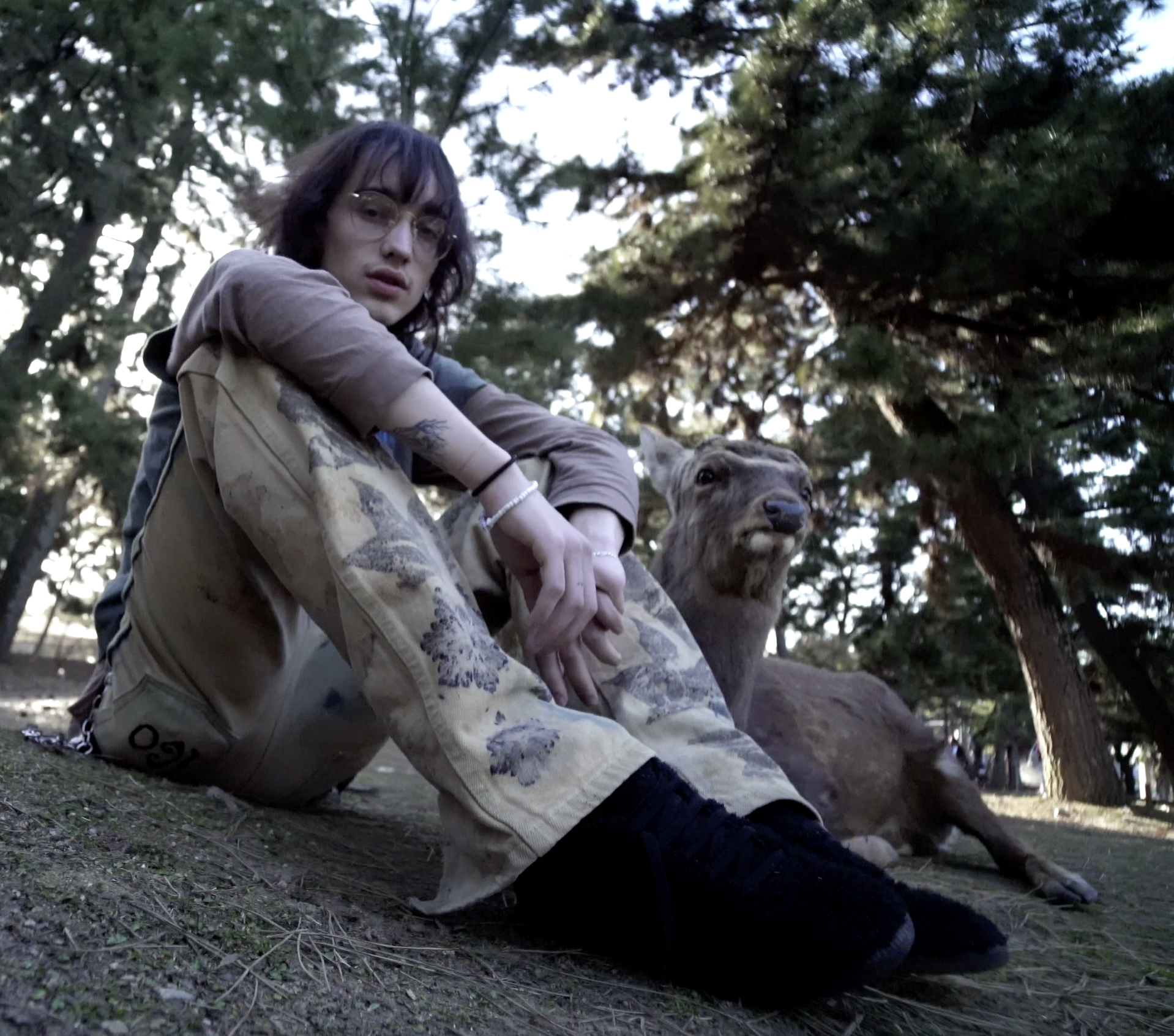 Person auf einem Stein sitzend im Wald